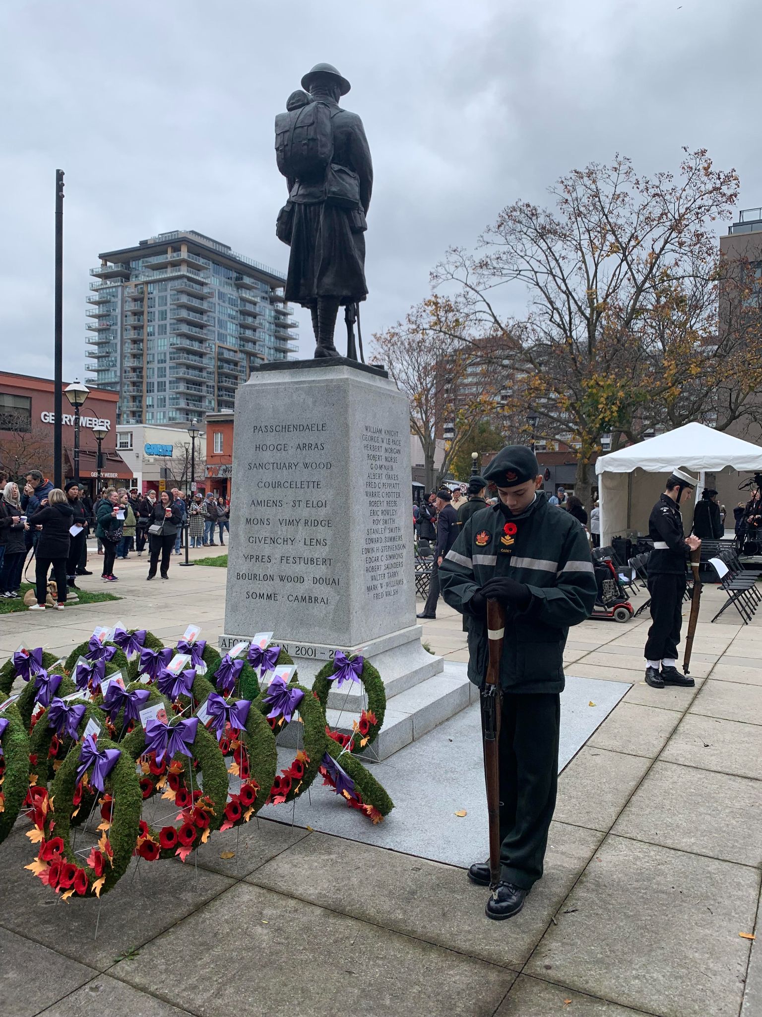 Cadet standing at attention beside the memorial during the event