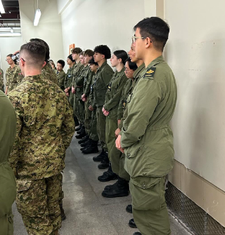 Instructor guiding a cadet through a hands-on practical activity