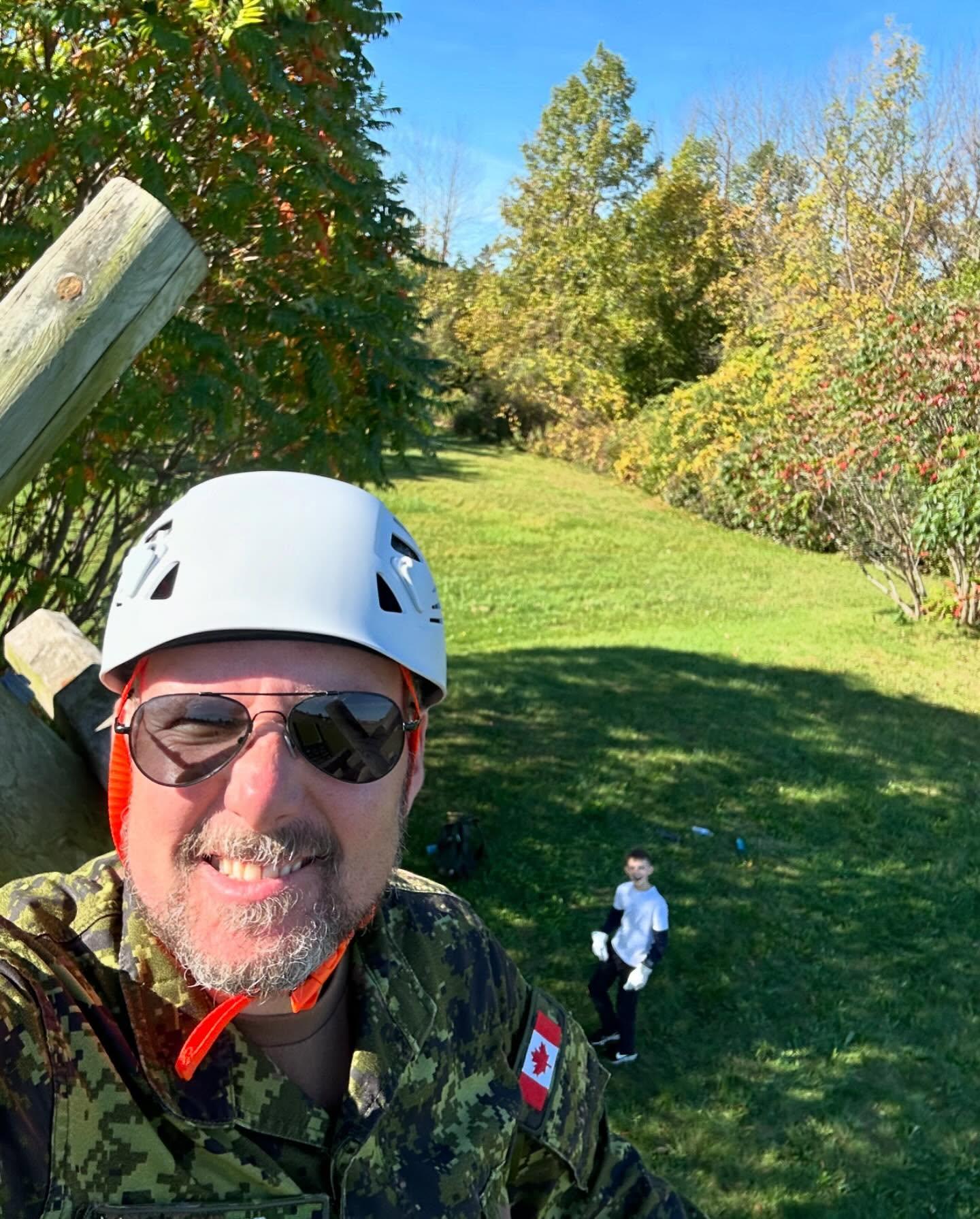 Cadet smiling while climbing over the obstacle course wall
